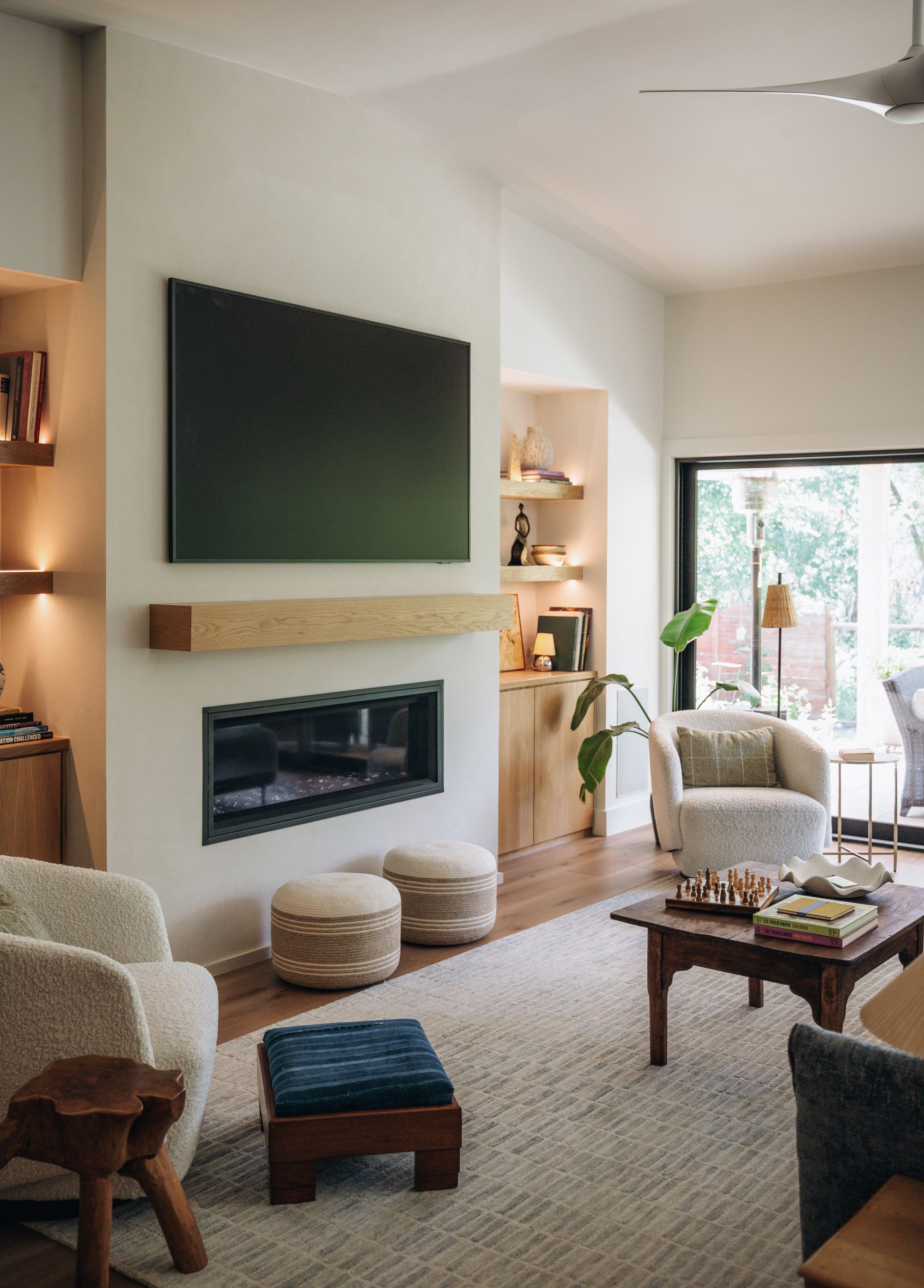 Living room fireplace with floating oak mantel and built-in shelving