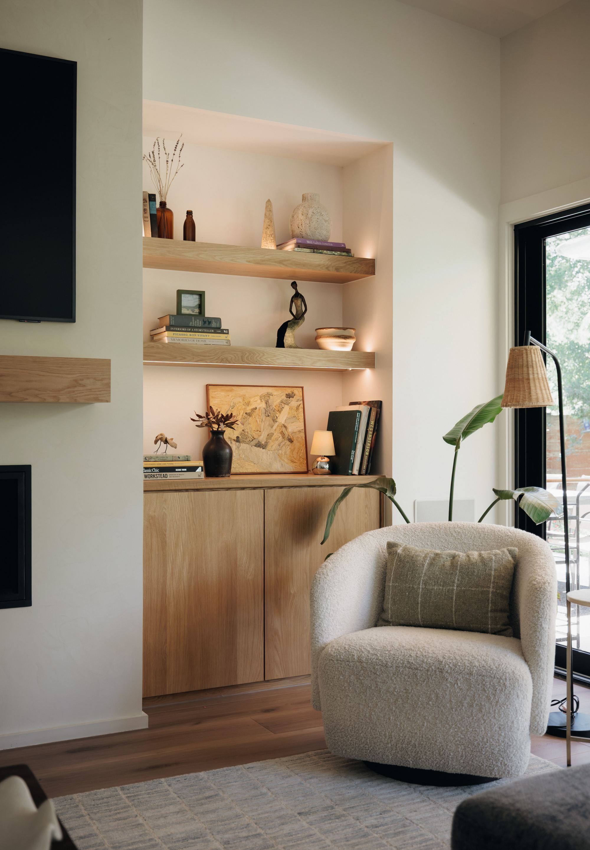 Reading nook with built-in shelving and a boucle swivel chair