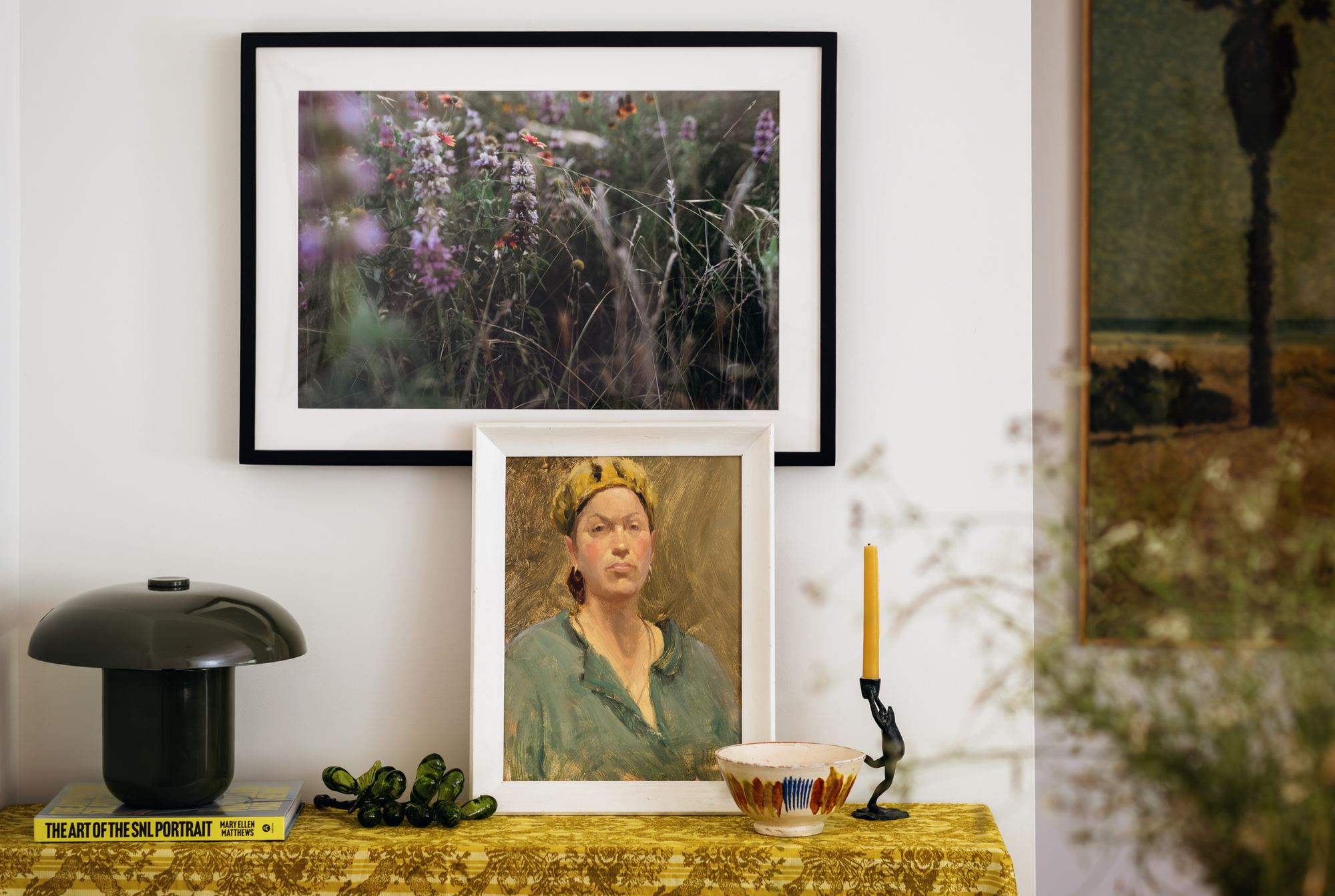 Console styling with framed art, a vintage portrait, and decorative objects