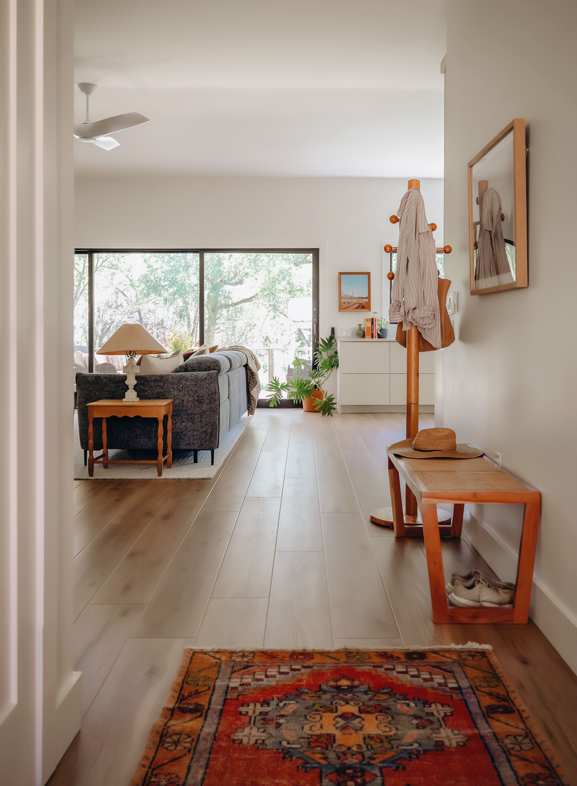 Entryway with a coat rack, bench, and vintage rug