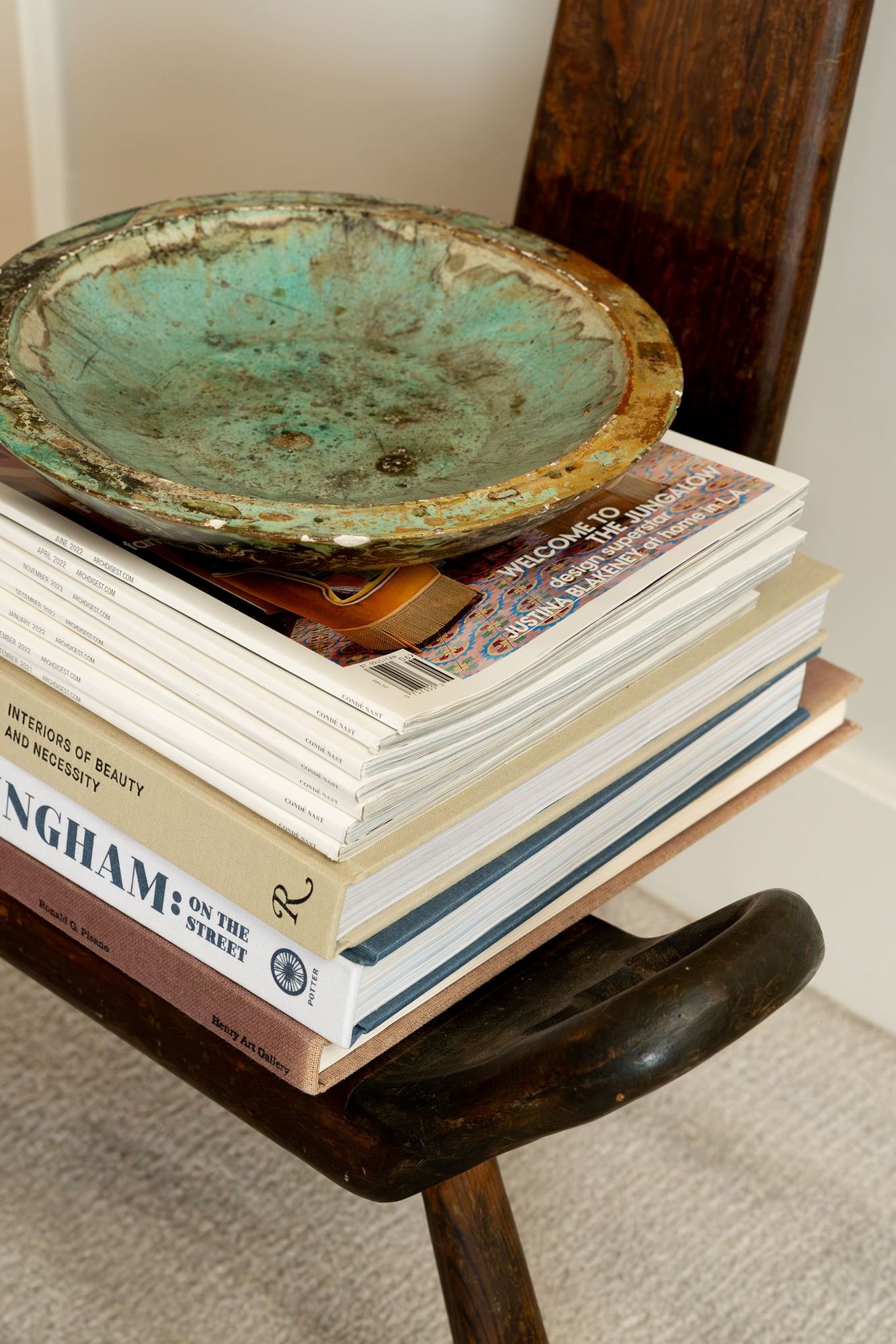 Styled stack of design books and magazines with a patinated bronze bowl