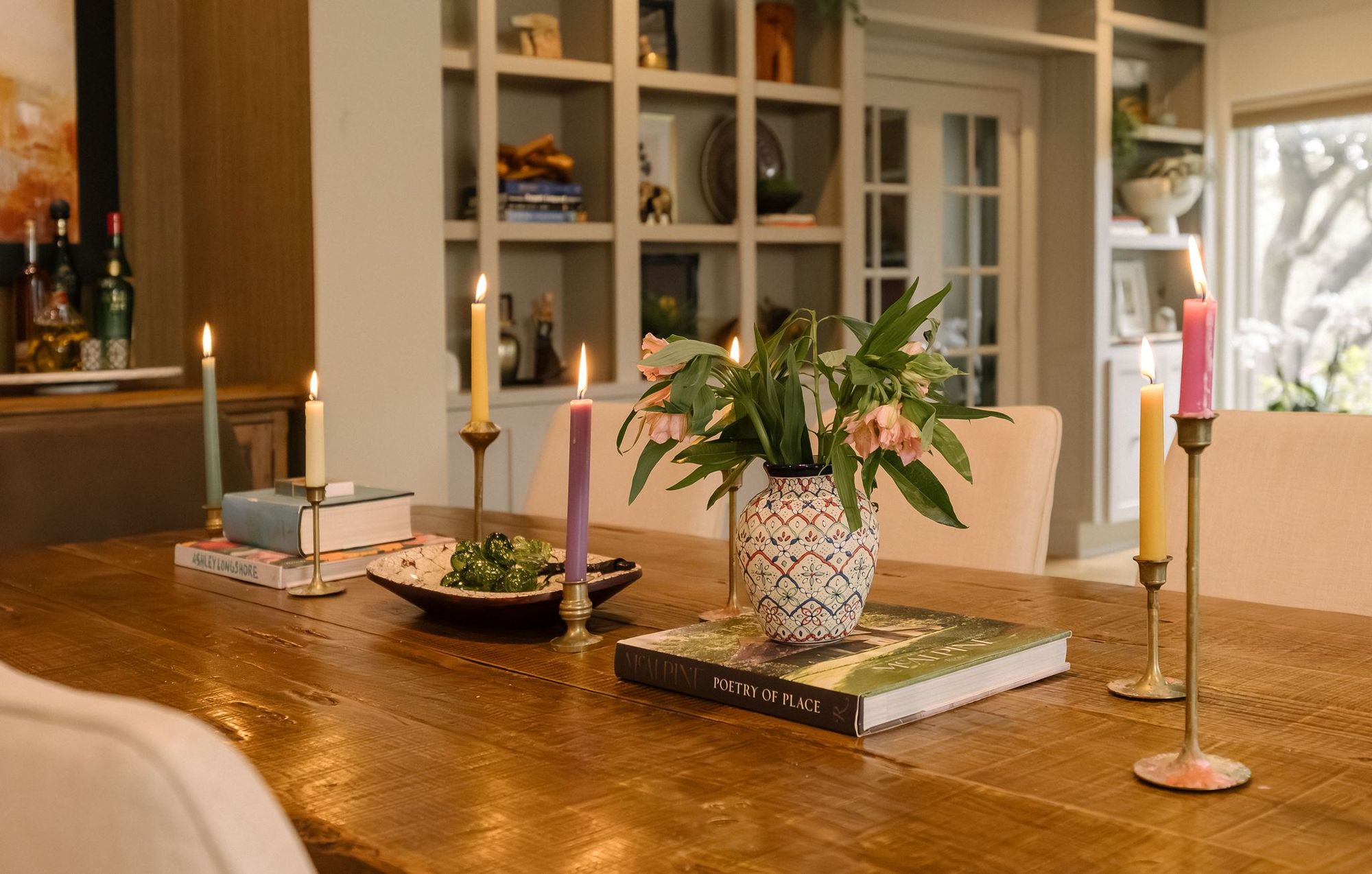 Dining table styled with taper candles and a floral centerpiece